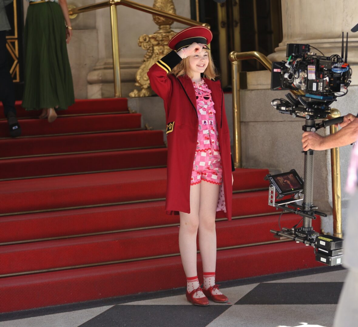 Mae Schenk wears a red ensemble to film scenes outside the Plaza Hotel for ELOISE