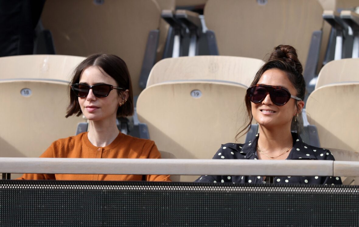 Charlie McDowell and Lily Collins sitting with Ashley Park at the stands during the French Open tennis tournament