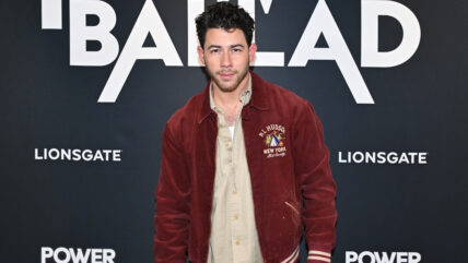 Nick Jonas wearing a red jacket